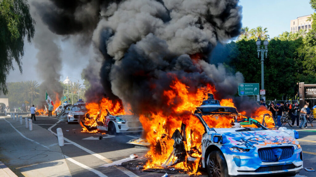 protesters-summon,-burn-waymo-robotaxis-in-los-angeles-after-ice-raids